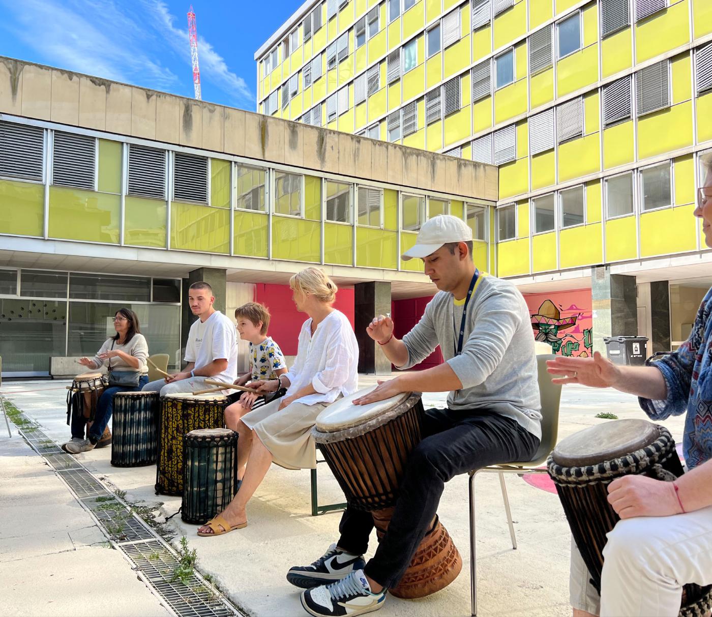 Des gens qui jouent de la percussion dans la cour d'un immeuble